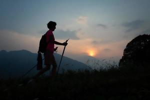 flicka under en solnedgång kväll vandra i de kullar foto