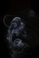 ritningar av rökelse rök på en svart bakgrund foto