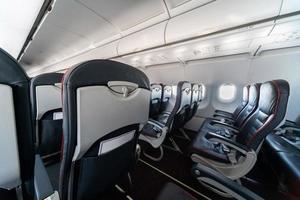 flygplansstolar och fönster. ekonomiklass bekväma säten utan passagerare. nytt lågprisflygbolag foto