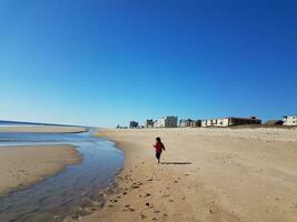 vatten strömmande i flod på strand nära hav med pojke foto