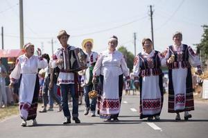 belarus, aftyuki by, juli 31, 2021. etnisk semester.vitryska människor med etnisk musikalisk instrument är gående genom de by. foto