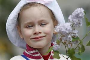 belarus, de stad av gomil, Maj 16, 2016. en liten flicka i en panama hatt innehar en kvist av syrener. foto