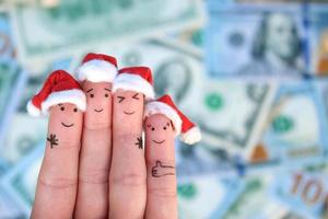 fingrar konst av vänner firar jul på de bakgrund av pengar. de begrepp av en grupp av människor skrattande i ny år hattar. foto