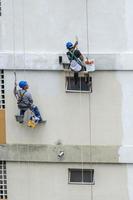 rio, Brasilien, november 04, 2022, pater Arbetar på bostads- byggnad Fasad återhämtning förbi rep som en klättrare foto