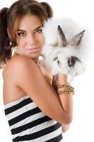 härlig ung kvinna med liten vit kanin foto