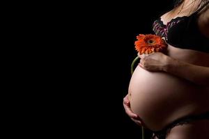 mage av en gravid kvinna med blomma foto
