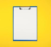 blå papper hållare med vit tom ark på gul bakgrund foto
