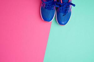 par av sporter gymnastikskor med blå skosnören på en färgad abstrakt bakgrund foto