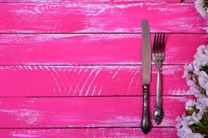 årgång gaffel och kniv på en rosa trä- yta foto