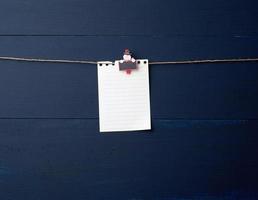 tömma vit anteckningsbok papper ark hängande på dekorativ Semester klädnypa foto