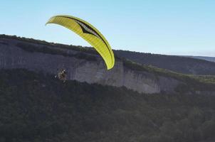 paraglider flygande över bergen foto