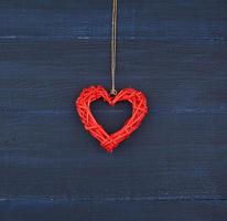 röd korg- dekorativ hjärta hängande på brun rep foto