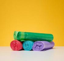 stack av disponibel plast skräp kan påsar på en gul bakgrund foto