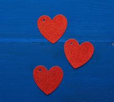papper röd skinande dekorativ hjärtan på mörk blå trä- bakgrund foto