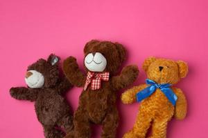 tre teddy björnar på en rosa bakgrund, vänskap begrepp foto