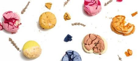 bruten runda macarons med smulor på en vit bakgrund, utsökt efterrätt foto