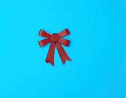röd skinande rosett för dekoration gåvor på en blå bakgrund foto