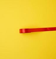röd silke band på en gul bakgrund, festlig bakgrund foto