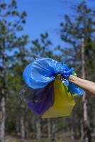 mänsklig hand innehar många flerfärgad tömma transparent påsar för sopor foto