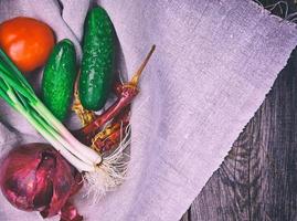 färsk tomat grönsaker, gurkor och grön lök foto