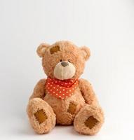 brun årgång teddy Björn med plåster, vit bakgrund foto