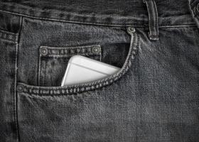 smartphone i de främre ficka av svart jeans foto
