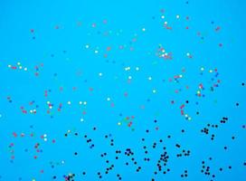 skinande flerfärgad runda konfetti spridd på en blå bakgrund foto