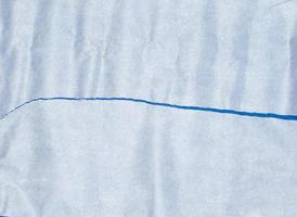 trasig bit av vit pergament papper på en blå bakgrund foto