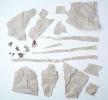 en uppsättning av olika bitar av trasig grå skrynkliga papper på en vit bakgrund foto