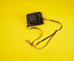 gammal filma kamera i en brun läder fall på en gul bakgrund foto