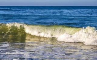 ytterst enorm stor surfare vågor på strand puerto escondido Mexiko. foto