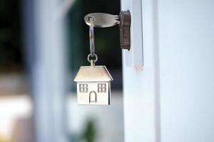 Hem nyckel för upplåsning de ny hus dörr. hyra, uppköp, försäljning hus foto