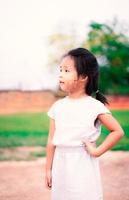porträtt av söt liten flicka står i parken foto