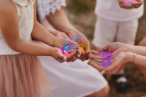 händer av barn och vuxna i de färger av de hall. familj har roligt med holi målarfärger utomhus. holi Färg festival foto