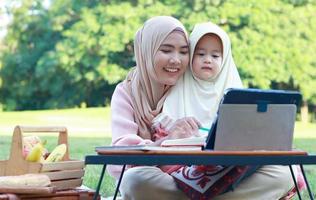 muslimska mödrar och döttrar njuter av sin semester i parken. kärlek och band mellan mor och barn