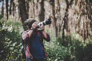 ung fotograf som tar bilder i skogen foto