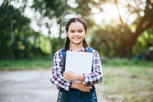 ung kvinnlig student som håller en bok foto