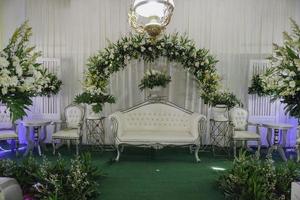 inomhus- dekoration uppsättning upp för javanese bröllop med en massa av färsk blommor. foto