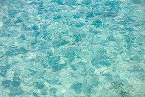 naturlig blå vatten yta med ljus Sol ljus reflektioner, vatten i simning slå samman bakgrund. hav vatten konstnärlig bakgrund foto