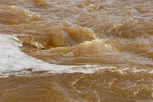 grumlig flod vatten. smutsig grumlig vatten med bubbelpool och vit skum närbild. foto