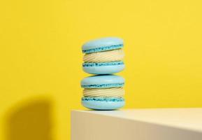 bakad blå runda macarons på en gul bakgrund, utsökt efterrätt foto