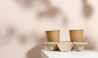 papper kartong brun koppar för kaffe och te, beige bakgrund. miljövänlig servis, noll avfall foto