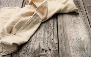 vikta beige Linné handduk på en tabell tillverkad av gammal grå trä- brädor, topp se foto