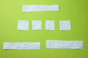olika bitar av vit papper i en blå bur på en grön bakgrund foto