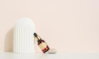 brun glas flaska med en pipett och en brun märka står på en sten. behållare för kosmetika, serum och olja. attrapp hudvård produkt foto