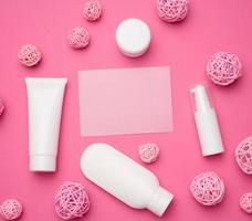 tömma papper kort och flaska och tömma vit plast rör för kosmetika på en rosa bakgrund. förpackning för grädde, gel, serum, reklam och produkt befordran foto