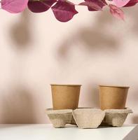 papper kartong brun koppar för kaffe och te, beige bakgrund. miljövänlig servis, noll avfall foto