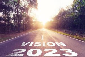 tömma asfalt väg och ny år 2023 begrepp. körning på ett tömma väg till syn 2023 med solnedgång. foto