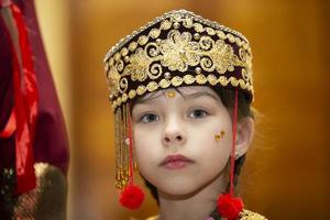 belarus, stad av gomel, Maj 21, 2021 barns Semester i de stad. en liten flicka i de uzbekiska nationell huvudbonad. foto
