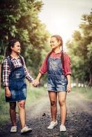 två unga flickor som går längs en skogsväg foto